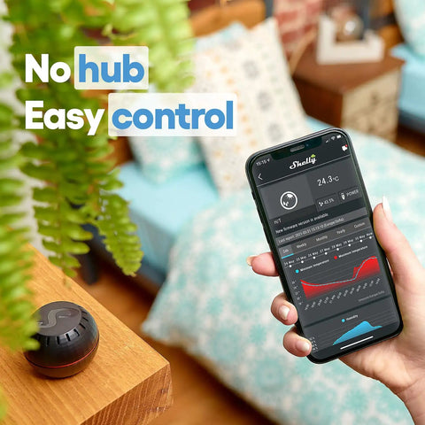 Person holding a smartphone with app displaying 24.3°C readings next to HT Black WiFi Temperature And Humidity Sensor, smart home setup.