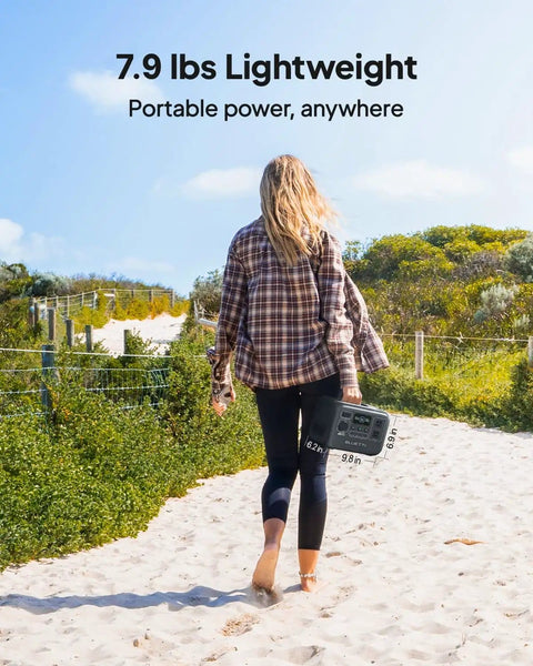 Person walking on a sandy path carrying Portable 204Wh LiFePO4 Solar Generator With Two 300W AC Outlets Six Output Ports