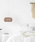 Fitz 1-Light Pendant Light With Blonde Rattan Shade And White Socket, Plug-In Or Hardwire Ceiling Mount in a cozy bedroom.