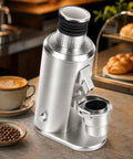 Heavy Duty 80mm Stainless Steel Flat Burr Coffee Grinder With 550W Adjustable Motor And Single Dose Bellows Hopper in silver, placed beside a coffee cup.