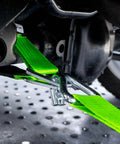 Heavy Duty Axle Tie Down Kit Featuring Hella Bright Neon Green 2 Inch Webbing And Reliable Wire J Hook Ratchet Straps securely fastening a vehicle.