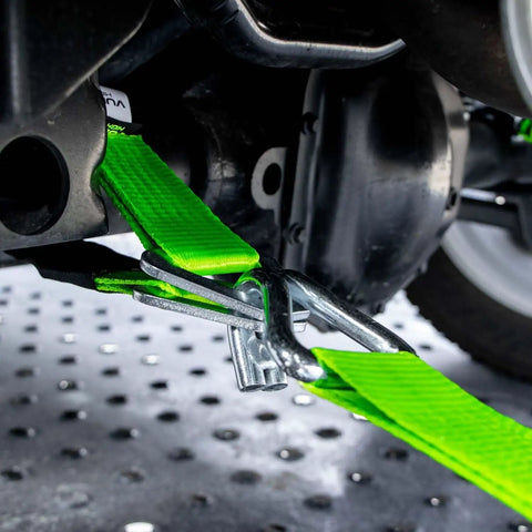 Heavy Duty Axle Tie Down Kit Featuring Hella Bright Neon Green 2 Inch Webbing And Reliable Wire J Hook Ratchet Straps securely fastening a vehicle.