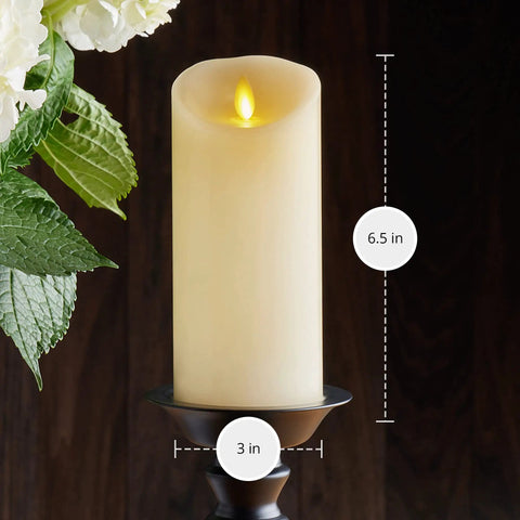 Scalloped Edge Flameless LED Candle Ivory 3x6.5 Inch Battery Operated With Moving Flame Real Wax Pillar Timer Vanilla Honey Scent Remote Ready Cozy Home Decor Upgrade on a dark background next to flowers.