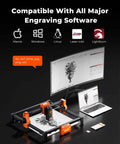 ACMER S2 12W laser engraver with black frame and orange components; connected to monitor and laptop.