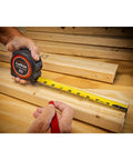 Pro Grade 1-3/16 Inch By 35 Foot Tape Measure With Anti Pinch Retract being used on wooden planks for precise measurement.