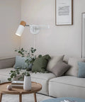 Plug In Swing Arm Wall Lamp With Wood Head, Modern White Finish, in living room, UL-listed, adjustable arm and swivel, above sofa.