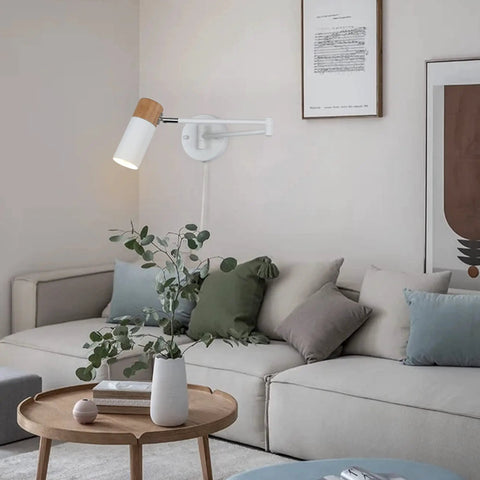 Plug In Swing Arm Wall Lamp With Wood Head, Modern White Finish, in living room, UL-listed, adjustable arm and swivel, above sofa.