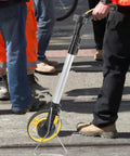 Jiawu Digital Display Distance Measuring Wheel Foldable Hand Push Roller Rangefinder on construction site for accurate measurement.