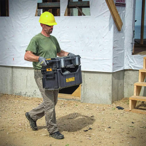 Man carrying Heavy Duty Tool Organizer Bag For Tough System Stacks With Large Open Interior For Bulk Storage Holds Spray Cans Cables And Tools Durable Polypropylene Tote With Side Carry Handle And Stacking Latch For Easy Transport at construction site