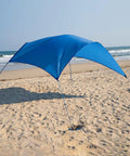 Beach Wind Powered Shade Canopy Portable Sun Shelter Tent with UPF 50 Plus UV Protection, providing shade on a sandy beach.