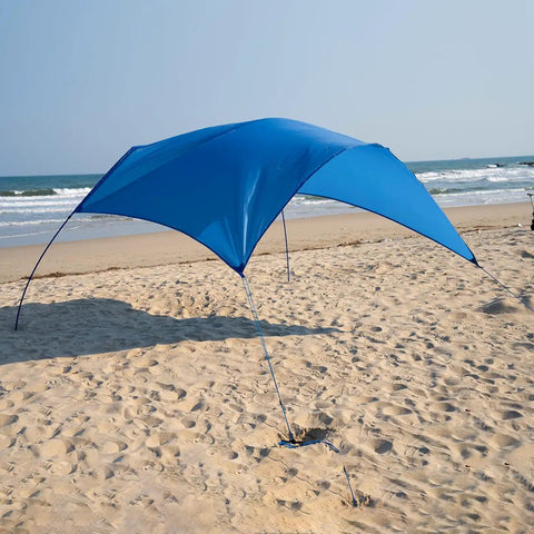 Beach Wind Powered Shade Canopy Portable Sun Shelter Tent with UPF 50 Plus UV Protection, providing shade on a sandy beach.
