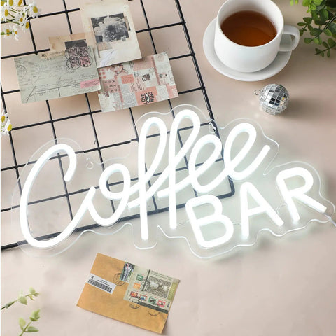 Coffee Bar Neon Sign LED Light for Cafes and Bars on table with postcards and teacup, modern wall decor, bright white glow artwork