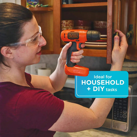 Woman using Ultra Lightweight 8V Max Cordless Drill Driver For Home DIY on kitchen cabinet for household task.