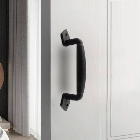 Black steel 8 inch sliding barn door handle installed on white cabinet door, showing sturdy construction and modern farmhouse design.