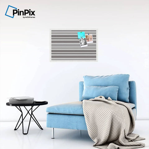 Custom Printed Canvas Bulletin Board With Graphite Grey Bold Stripe Design, 30 By 20 Inches, Framed In Satin White Frame, Ready To Pin Photos, Notes, And Recipes installed on a wall above a blue sofa.