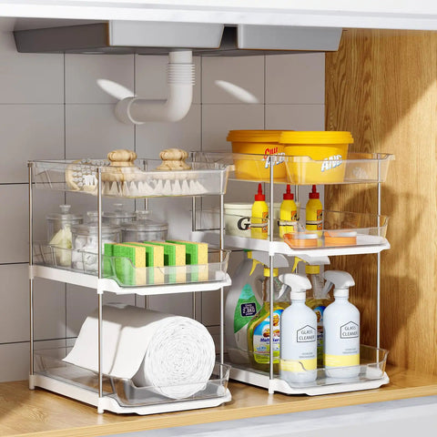 Total Game Changer Clear Three Tier Under Sink Organizer Two Pack with cleaning supplies and sponges in a cabinet.