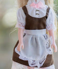 Doll wearing a brown dress with lace, featuring golden metal buttons for 100Pc Mini Buttons For Doll Clothes DIY Fasteners Kit.