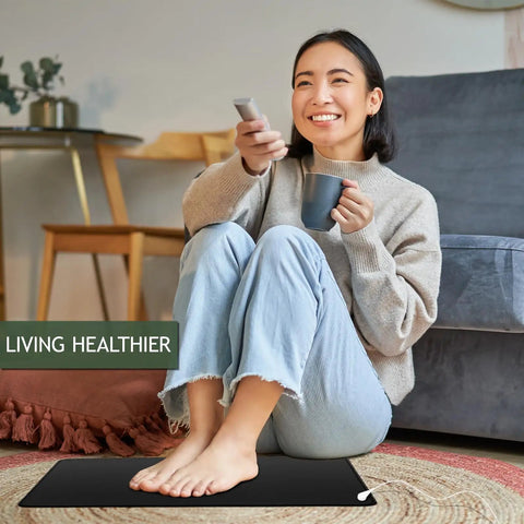 Woman sitting on All In One Grounding Mat Kit With 15Ft Cord For Foot Mats Computer Desk And Sleep Mat Pet Friendly Super Soft Surface