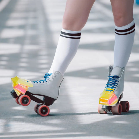 Person wearing quad skates with Dope 4 Pack Toe Cap Guards For Roller Skates Protectors Set In Glossy Pattern Light Pink And Blue.