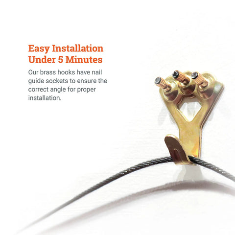 Close-up of Beefy Heavy Duty 100 Pound Picture Hanging Hooks with brass finish, nails, and wire for drywall installation.