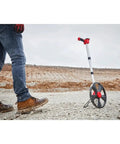 Super Slick 12 Inch Digital Measuring Wheel With Illuminated Backlit Panel And Telescoping Handle on rough terrain.