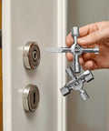 Hand holding TwinKey Multifunctional Spanner Kit With Magnetic Eight Arm Two By Four Way Spider Keys in front of lock.