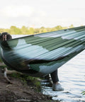 Person relaxing in Roo Double Hammock with GravitasX water resistant breathable ripstop fabric by the lake