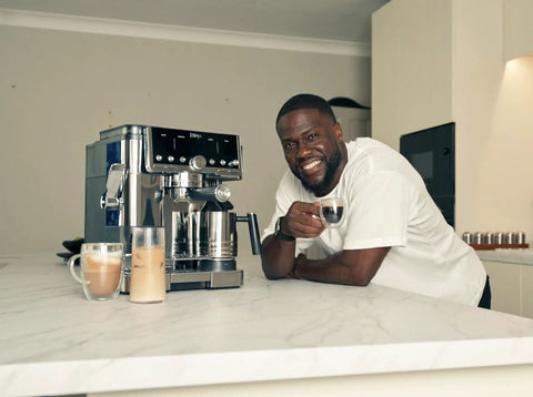 Person enjoying coffee beside Luxe Café Pro Series 4 In 1 Espresso Machine With Built In Grinder And Integrated Tamper