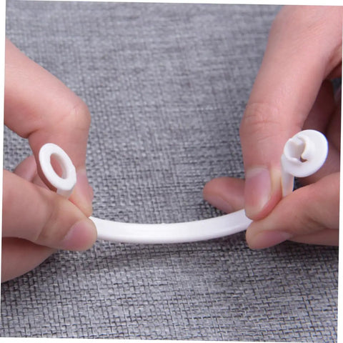 Hands holding a white plastic curtain ring from 60 Pack Plastic Circular Curtain Rings For Rods With Smooth Glide No Burr.