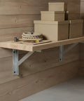 Beefy Heavy Duty Angled Shelf Bracket for Wood to Wood and Wood to Wall Framing, supporting a wooden shelf with items on top