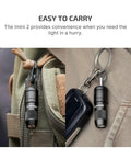 Imini 2 EDC Rechargeable Keychain Flashlight with 50 Lumens Output attached to backpack and keyring, showcasing everyday carry convenience.