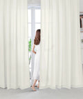 Woman stands between Beige Farmhouse Sheer Curtains 95 Inch Long For Living Room And Bedroom Cozy Light Filtering Semi Sheer Panels 2 Panels Rod Pocket Privacy Drapes For Window Treatment.