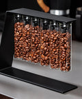 Glass Coffee Bean Storage Tubes Set Of Six With One Way Degassing Valve And Magnetic Stand And Single Dose Espresso Dosing Vials To Keep Your Java Fresh As A Daisy While Handling Your Essential Daily Grind Session, filled with roasted coffee beans.