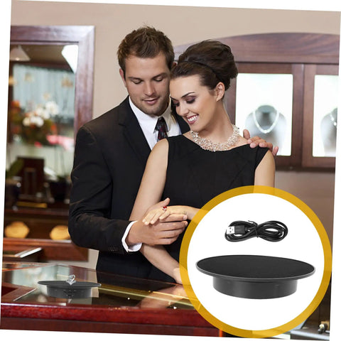 Couple admiring jewelry with Smooth Rotating Jewelry Display Stand With Adjustable Speed Motorized Turntable For Retail Store Showcase And Product Photography Features Black Base And Convenient Usb Connectivity For Easy Power On Anywhere.