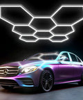 Hexagon Garage Light With Ultra Bright 38880 Lumen Output, 6500K Daylight White, 8 Grid Anti Glare LED Fixture above a car