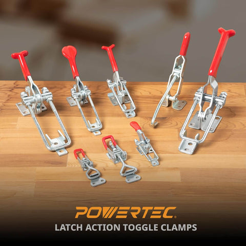 Various sizes of toggle clamps with red hand grips displayed on a wooden surface