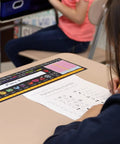 Top Shelf Chalkboard Style K-2 Desk Reference Mats on a desk with a student completing a worksheet, premium plastic teaching aids.