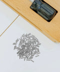100 Pieces Carbon Steel M2.5x10 Hex Socket Headless Grub Screws For Door Handle Repair And Bath Fixtures Plus Delicate Assembly Work Ensure Grip And Security Like a Boss For Tackling Your Next Job. Silver M2.5x10 carbon steel grub screws beside a door handle latch.