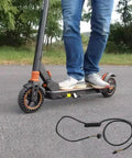 Person riding electric scooter with a coiled Electric Scooter Controller Cable With LCD Display Extension Wire 60cm Fits S1 And S3 ABS Replacement Part Easy Install Plug And Play Strong Connection High Conductivity Wiring For Clear Readouts And Smooth Power Delivery on pavement