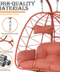 Close-up of orange-red Double Egg Chair With Stand And Adjustable Canopy showing cushions and durable steel frame.