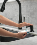 Hands using Essa Kitchen Faucet Soap Dispenser Accessory Matte Black With Metal Construction, Refills From Above Deck on marble countertop