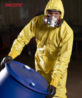 Worker in protective suit and respirator handling a blue drum in industrial setting