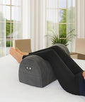 Carepeutic Contoured Leg Rest Wedge With Vibration Massage And Heat placed on a bed supporting legs, featuring a grey soft touch surface.