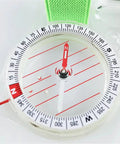 Close-up of compass dial on the All In One Thumb Compass With Ruler For Hiking And Survival with green strap, showing north direction.