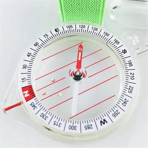 Close-up of compass dial on the All In One Thumb Compass With Ruler For Hiking And Survival with green strap, showing north direction.