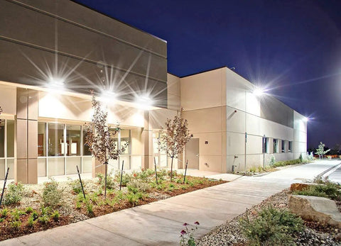 Building exterior illuminated by 120W LED Wall Pack Light Beast Bright 5000K 16200LM Dual Rotatable Panels, energy-efficient, weatherproof design.