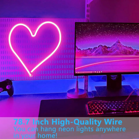 Pink Heart Neon Sign LED Light Up Wall Decor for Bedroom and Valentines Day Romance next to computer setup, dimmable.