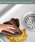 Cleaning the surface of a stainless steel sink with a cloth, showcasing the Wall Mounted Outdoor Kitchen Faucet with Filter Durable and Wear Resistant Professional Grade Perfect for Outdoor Cooking and Gardening Easy Installation.