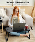 Foldable Laptop Bed Desk With Cup Holder, Tablet Slot And Lifting Handle in use for work on a sofa