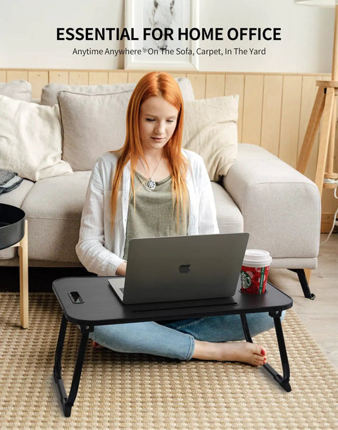 Foldable Laptop Bed Desk With Cup Holder, Tablet Slot And Lifting Handle in use for work on a sofa